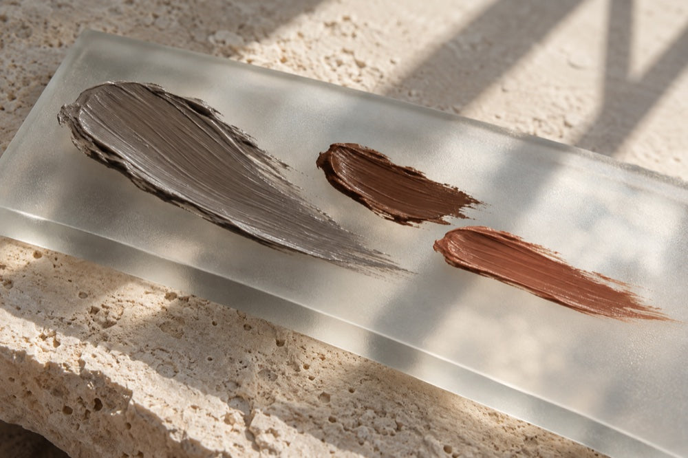 Editorial still life of grey and warm pigment strokes on glass, not a clinical result